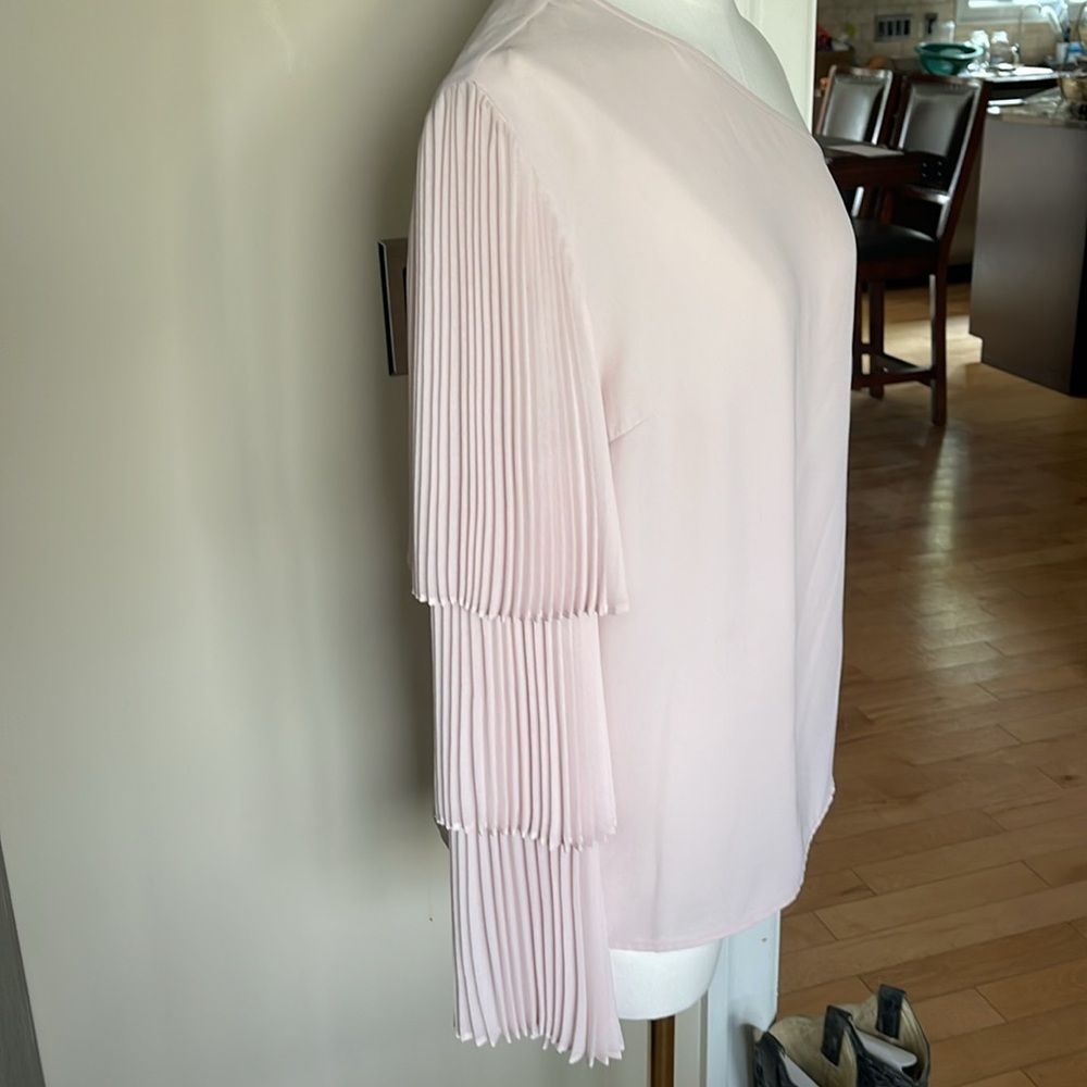 One shoulder blouse with a tiered flutter sleeve. Light pink. Size small.